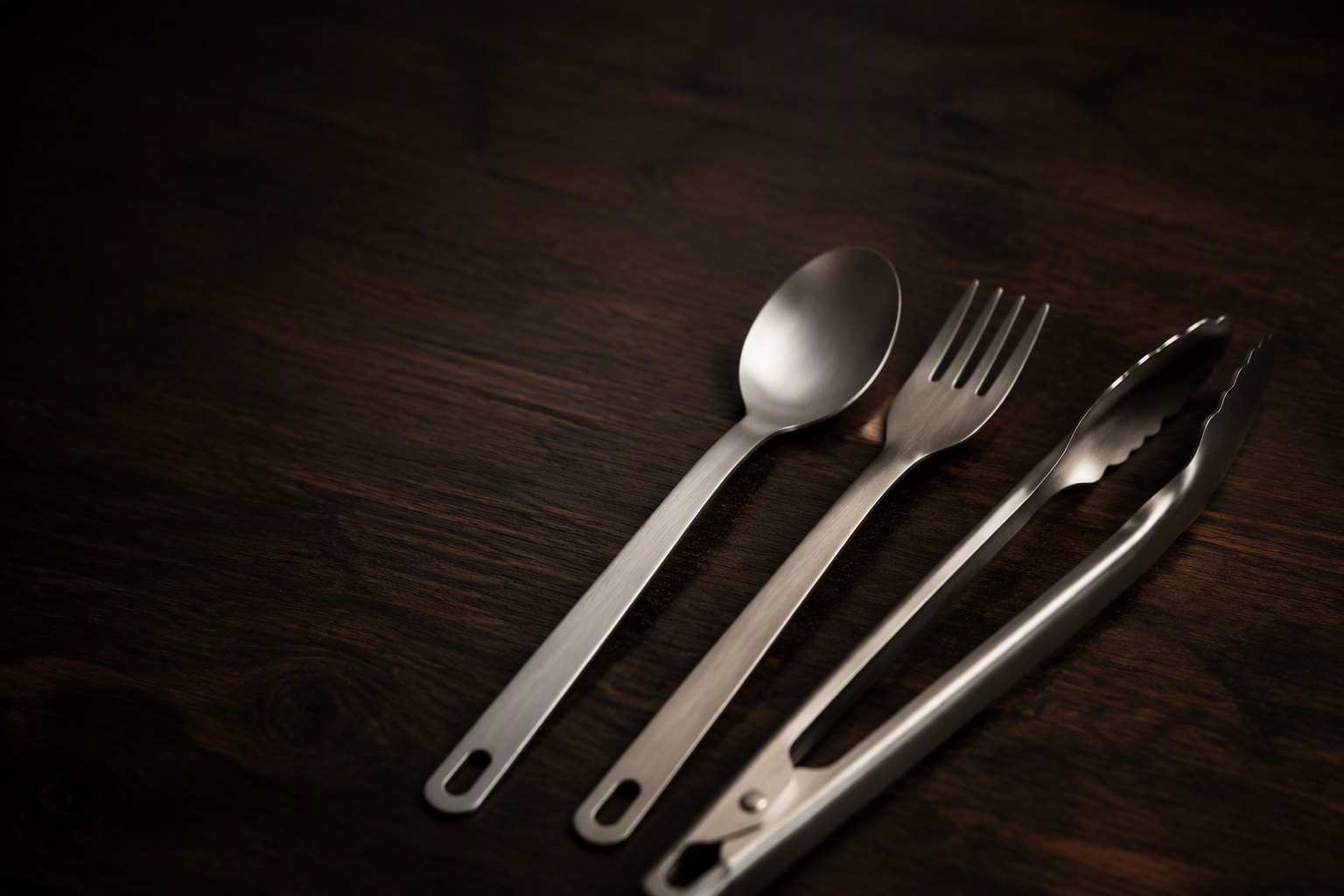 Titanium utensils on dark wood